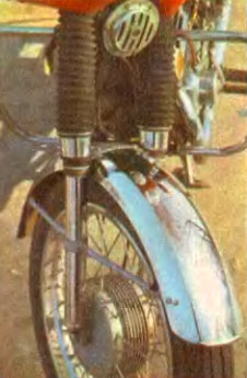 Резиновые чехлы на передней вилке ЯВЫ надежно защищают ее уплотнения от пыли, а хромированный щиток колеса придает нарядный вид мотоциклу (слева).